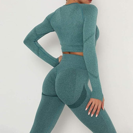 Een vrouw in een blauwgroen trainingsoutfit poseert zijwaarts, wat het ontwerp en de pasvorm van de Zie er geweldig uit en voel je geweldig benadrukt in deze 3-delige yoga workoutset!