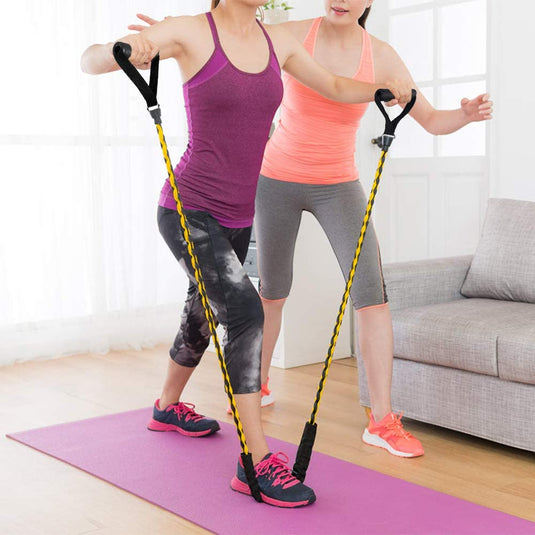 Twee vrouwen trainen binnenshuis met Ontdek de ultieme weerstandsbanden voor maximale kracht en comfort om de spierkracht te vergroten.
