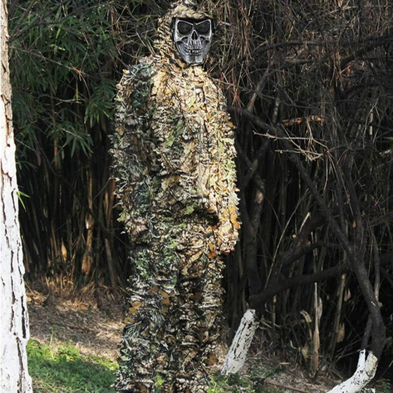 Laad afbeelding in Galerijviewer, Persoon die een Ontdek het ultieme camouflagepak draagt - Ghilliekostuum met een schedelmasker, staande in een bosrijke omgeving.
