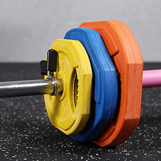 Close-up van een halterstang met gele, blauwe en oranje gewichtsschijven, vastgezet met een Haltersluiting van 25 mm op een gespikkelde sportschoolvloer. De belangrijkste fitnessaccessoires voor een veilige training met verbeterd evenwicht en coördinatie zijn goed zichtbaar.