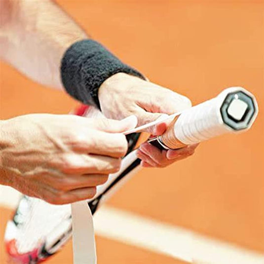 Iemand die een tennisracket opnieuw vastpakt met een Padel gripset: personaliseer je racket en verbeter je spel.