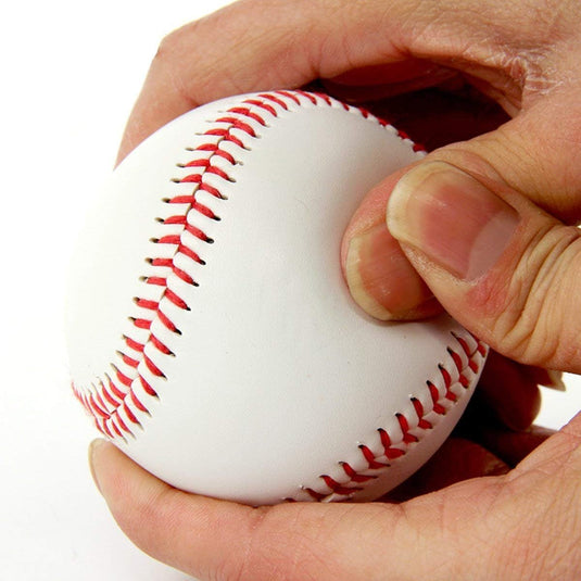 Een close-up van een hand die een Perfecte PVC honkballen trainingsballen vasthoudt met rode stiksels.