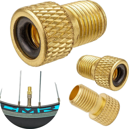 Messing Schrader ventieladapters met gekartelde zijkanten worden getoond. Eén is bevestigd aan een fietsventiel en twee andere worden apart getoond, wat de veelzijdigheid van onze