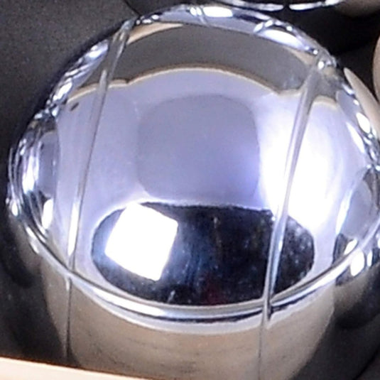 Close-up van een bolvormig reflecterend zilver "Geniet van eindeloos plezier met ons petanquespel in houten kist" met gesegmenteerde designelementen.