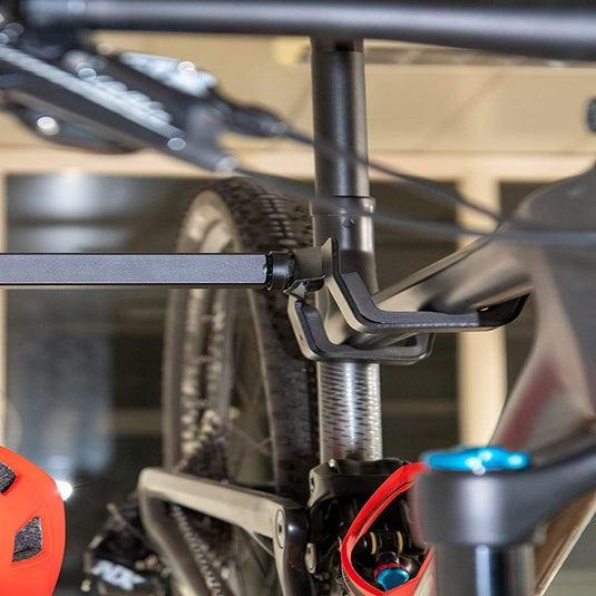 Close-up van een fietsframe met de zadelpenklem en een deel van het achterwiel met onze stijlvolle fietsopbergsysteemhaak.