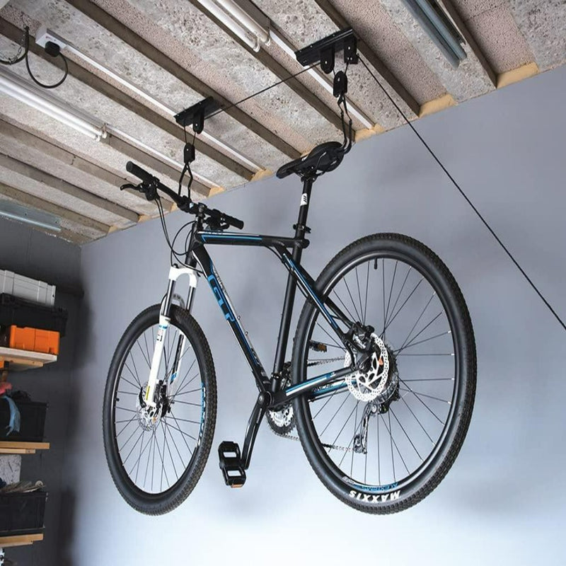 Laad afbeelding in Galerijviewer, Een mountainbike aan het plafond door de Optimaliseer uw ruimte en bescherm uw fiets met de innovatieve fietslift in een garage.
