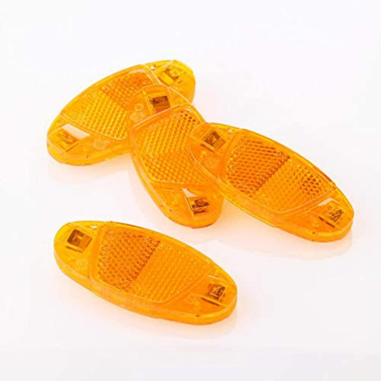 Een paar oranje, plastic schoenzolen in sandaalstijl met de fietsreflectorset, die de zichtbaarheid in het donker verbetert, op een witte achtergrond.