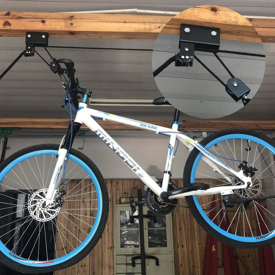 Optimaal ruimtegebruik en veiligheid: Ontdek onze fietslift met een witte en blauwe fiets die ondersteboven hangt aan de muur gemonteerd.