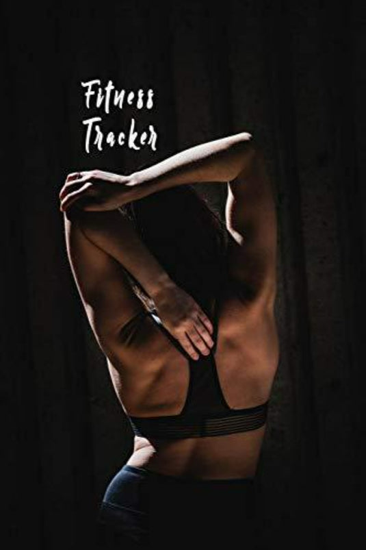 In een slecht verlichte kamer strekt een persoon zich sierlijk uit in een sportbeha. Een