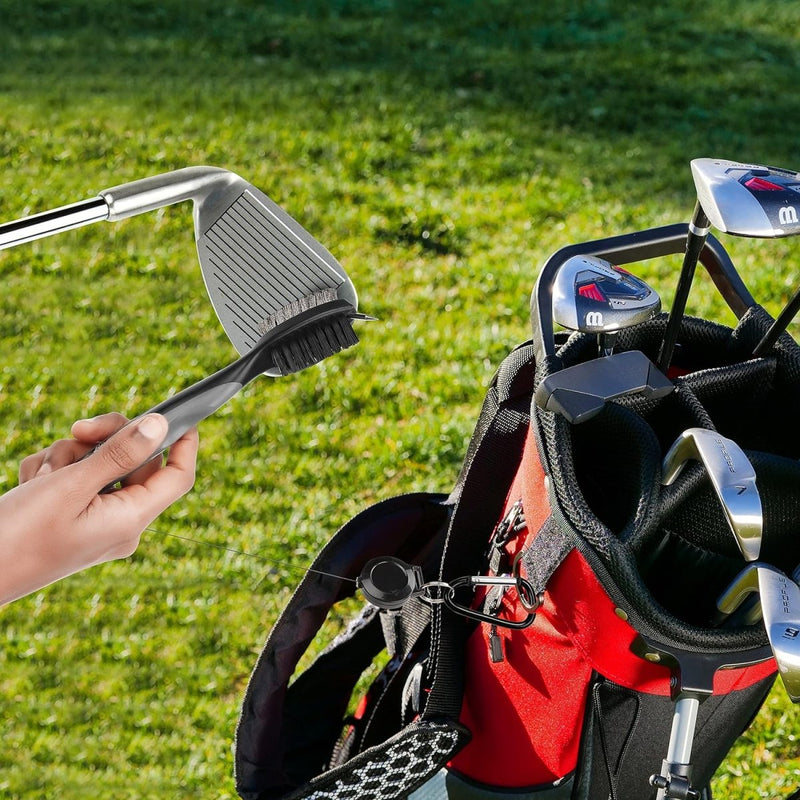 Laad afbeelding in Galerijviewer, Een golfclub schoonmaken met een Golfclubborstel en groovecleaner bij een golftas op gras.
