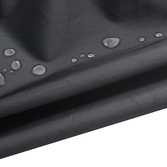 Close-up van een zwarte waterdichte stof gebruikt voor Hometrainer, fietsen en tuinmeubelen met zichtbare waterdruppels op het oppervlak.