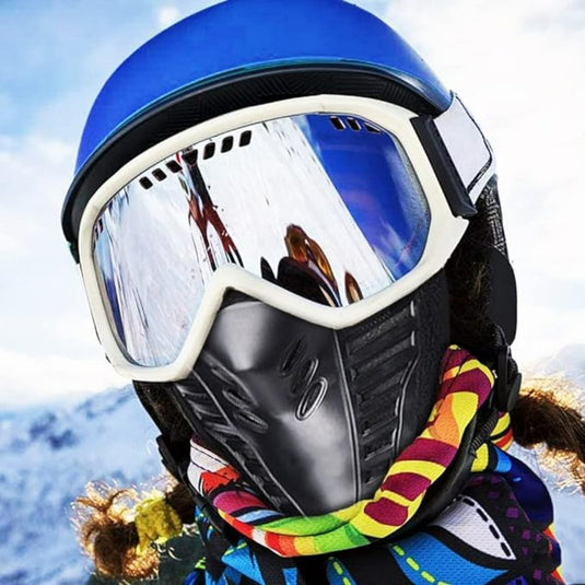 Een persoon die een skibril, een helm en een ademend gezichtsmasker draagt, met een bergachtige besneeuwde achtergrond weerspiegeld in de bril.
Houd je warm en veilig tijdens je winterse activiteiten met deze verbodene bivakmuts!