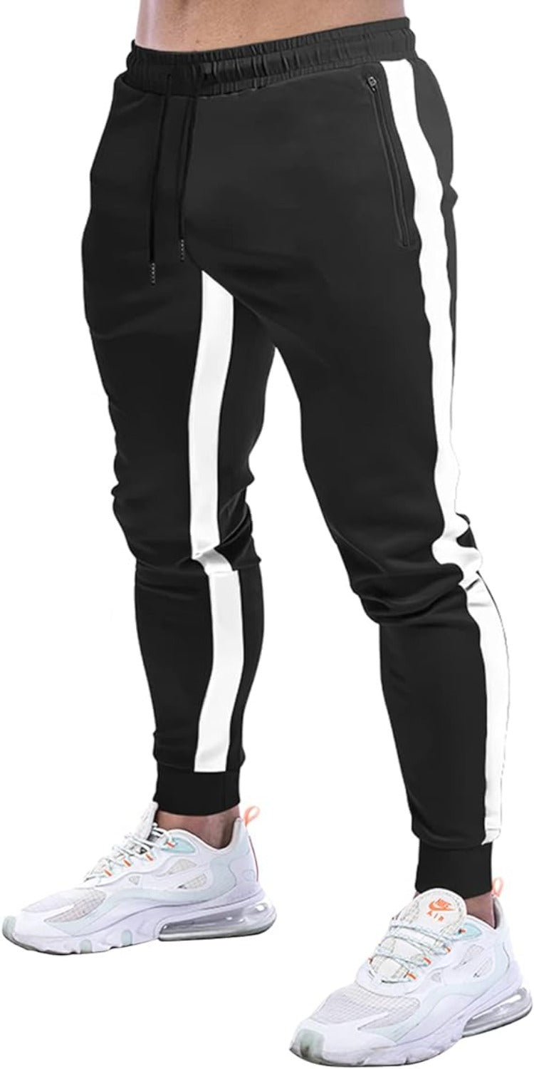 Laad afbeelding in Galerijviewer, Een persoon draagt stijlvolle zwarte joggingbroek voor heren met witte zijstrepen en witte sneakers.
