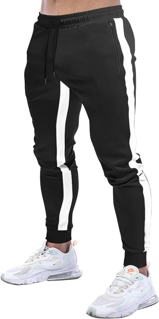 Een persoon draagt stijlvolle zwarte joggingbroek voor heren met witte zijstrepen en witte sneakers.