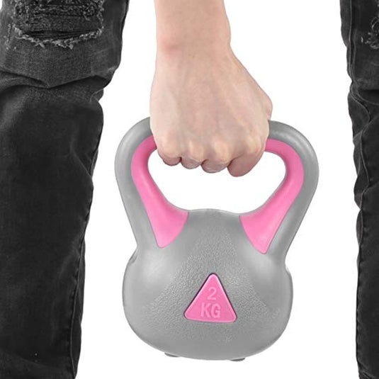 Iemand die de Ontdek de kracht van kettlebell oefeningen vasthoudt, ontmoette deze 2KG kettlebell met een roze handvat voor trainingen van het hele lichaam.