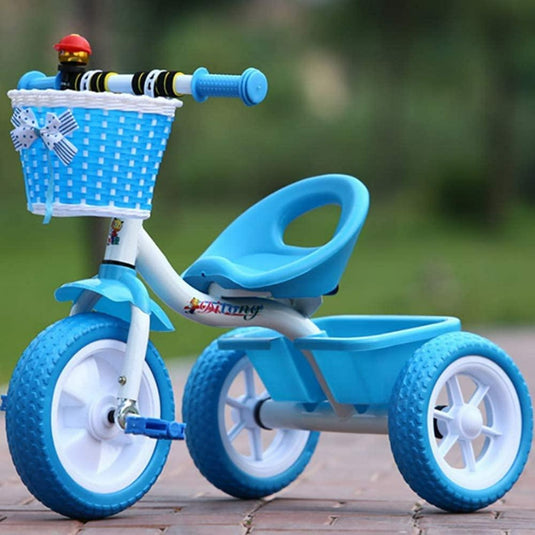 Een blauwe peuterdriewieler - Veilig, stijlvol en leuk met een achtermand en een voormand met een speelgoedfiguur op het stuur, veilig geparkeerd op een pad.