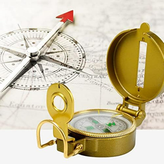 Een Betrouwbaar handheld lensatisch kompas met een uitstekende rode pijl over de achtergrond van een kaart, met een ander open kompas aan de zijkant.