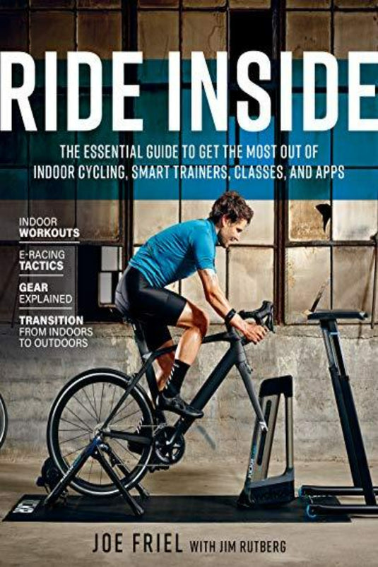 Er wordt een man in fietskleding getoond die bezig is met een indoor cycling-training op een hometrainer in een slecht verlichte omgeving, met de titel 