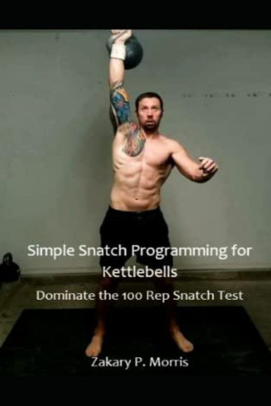 Man die een Simple Snatch Programming voor Kettlebells boven zijn hoofd tilt in een sportschool, met tatoeages op het bovenlichaam, met tekst-overlay over Simple Snatch Programming voor Kettlebells: Domineer de 100 Rep Snatch Test-programmering.