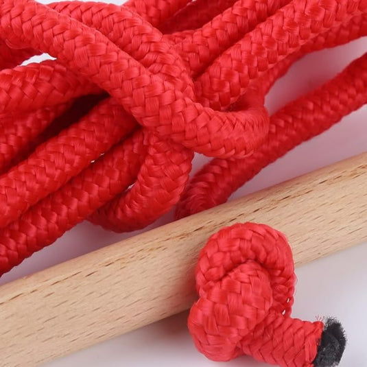 Close-up van een rode geweven sleeën met een houten stokje, mogelijk onderdeel van een speeltje.