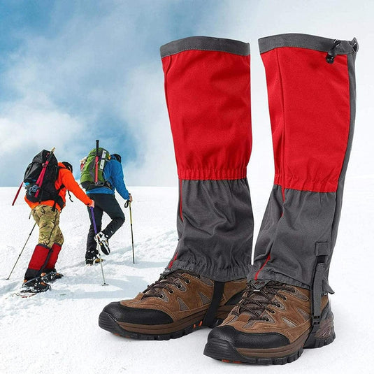 Paar rood en grijs Ontdek het ultieme comfort en bescherming met onze sneeuwgamaschen voor volwassenen op de voorgrond met wandelaars op een met sneeuw bedekte berg op de achtergrond.