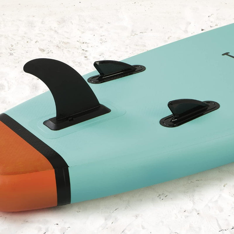 Laad afbeelding in Galerijviewer, Close-up van een Vitamine Sea stand-up paddleboard-vin en tractiepads op zand.
