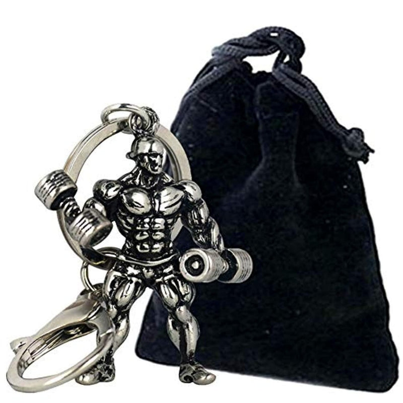 Laad afbeelding in Galerijviewer, Een metallic stijlvolle bodybuilder sleutelhanger, waarbij de sleutelhanger vastzit aan een grote ring, naast een klein zwart tasje met trekkoord.
