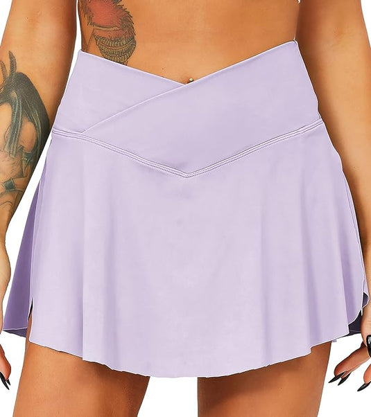 Close-up van een comfortabele lavendelkleurige Tennisrok met broek gedragen door een vrouw met een zichtbare tatoeage op haar bovenarm.