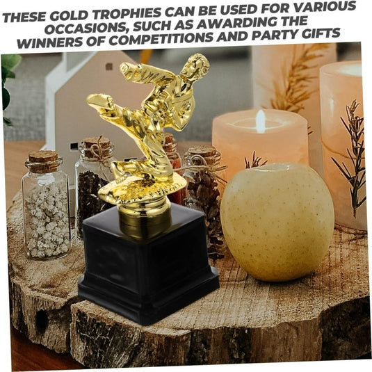 Vechtsport trofee met een uniek ontwerp en een beeldje op de top, fysieke tussen kaarsen en decoratieve potten op een houten oppervlak.