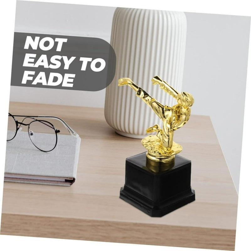 Laad afbeelding in Galerijviewer, Een gouden vechtsporttrofee: een geweldige herinnering aan jouw overwinning op een bureau, vergezeld van een bril en een vaas, met een label dat de hoge kwaliteit duurzaamheid tegen vervaging benadrukt.
