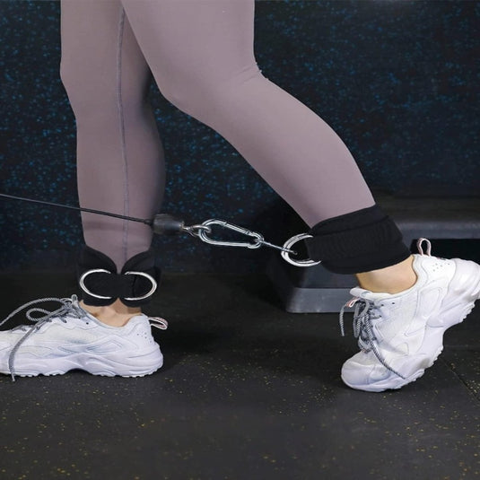 Benen in grijze leggings en witte sneakers met aan elke schoen een Versterk je been en billen met de voetlustrainer die een stap uitvoert.