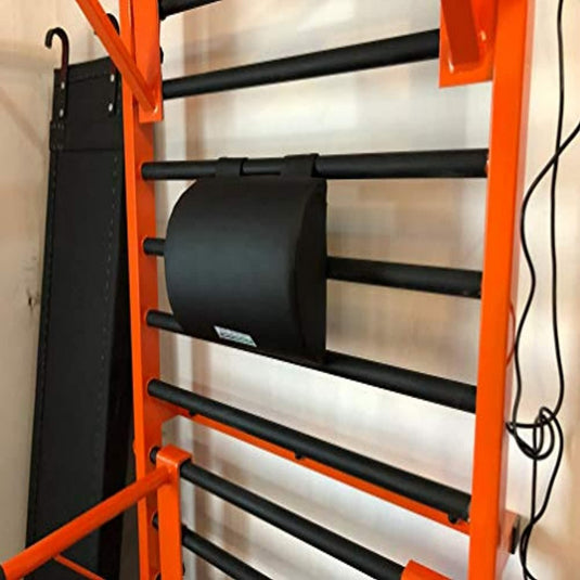 Zwarte buikroller hangend aan een grijs en oranje opbergrek met meerdere horizontale stangen, onderdeel van Ontketen je innerlijke kracht met onze veelzijdige metalen workoutset voor gymnastiek!