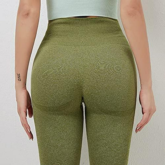 Close-up van een vrouw die een legging van groene, gestructureerde hoogwaardige stof draagt, met de nadruk op de rug en het taillegebied. De leggings zorgen voor comfort tijdens de yoga.