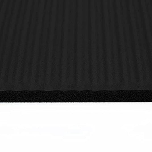 Close-up van een Ftalaatvrije yogamat die overgaat van een gestructureerd zwart oppervlak naar een glad wit oppervlak gemaakt van gerecycled materiaal.