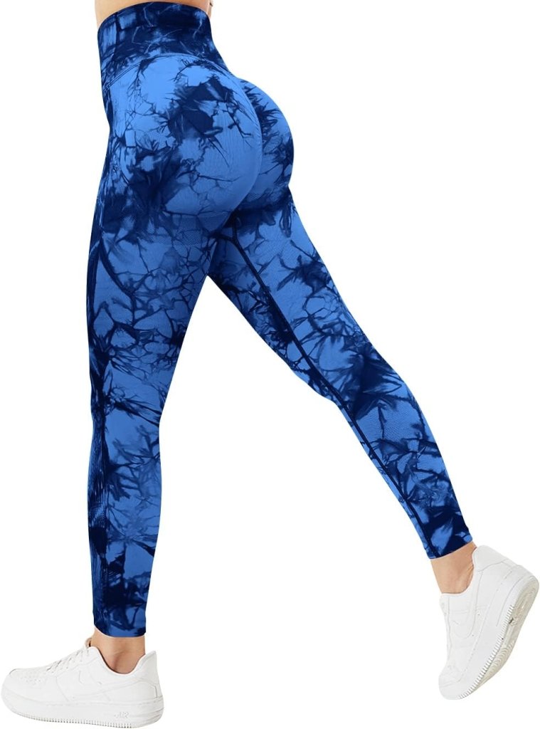 Laad afbeelding in Galerijviewer, Een persoon modelleert de &quot;Ervaar ultiem comfort en stijl met onze compressie sportlegging!&quot; in hoog getailleerde blauwe tie-dye met een geplooid billenontwerp, gecombineerd met witte sneakers, side-poserend tegen een effen achtergrond.
