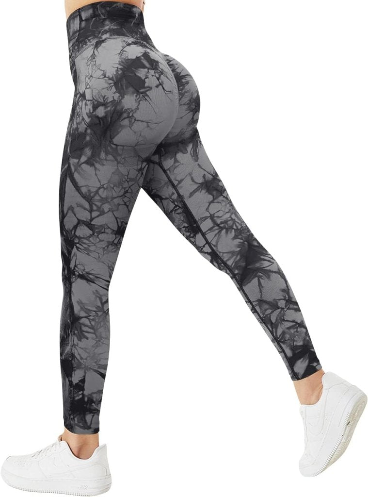 Laad afbeelding in Galerijviewer, Van achteren gezien draagt een persoon de Ervaar ultiem comfort en stijl compressie sportlegging in grijze en zwarte tie-dye met witte sneakers.
