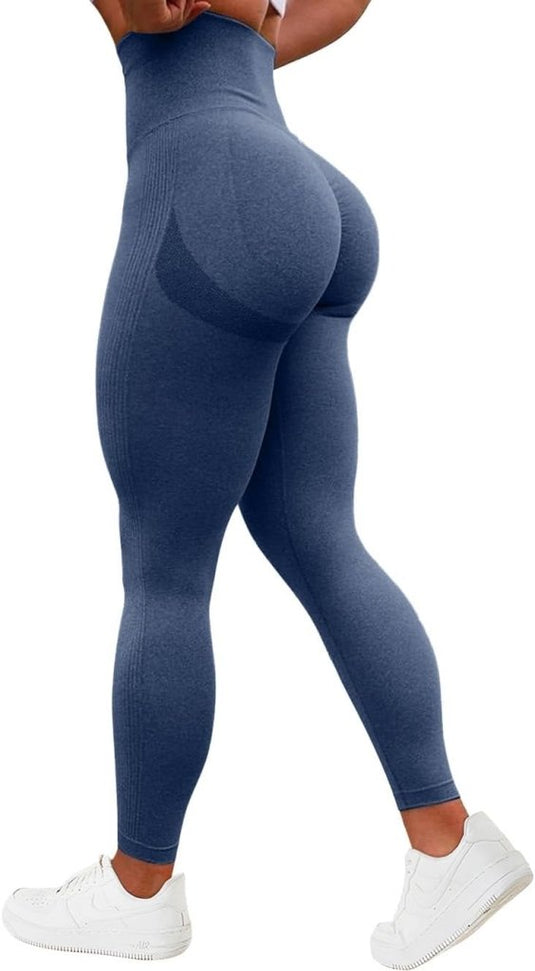 Een persoon wordt vanaf de achterkant getoond, gekleed in de Ervaar ultiem comfort en stijl compressie sportlegging in blauw met een geplooid billenontwerp, gecombineerd met witte sneakers.