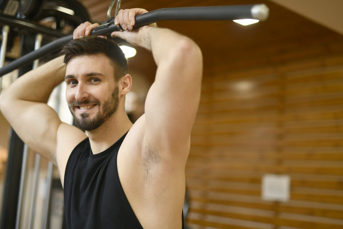 Een man is bezig met het heffen van gewichten in een sportschool.