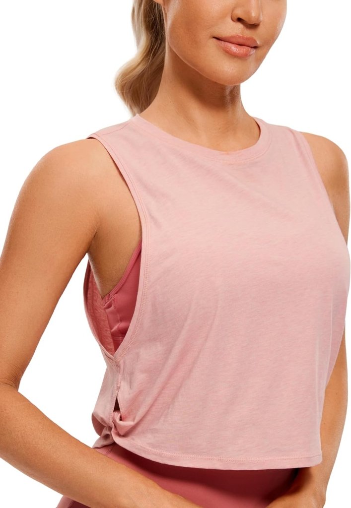 Laad afbeelding in Galerijviewer, Een persoon draagt een stijlvolle en comfortabele Yoga dames pima katoenen workout tanktop in roze, met uitsparingen aan de zijkanten, gecombineerd met een bijpassende sportbeha.
