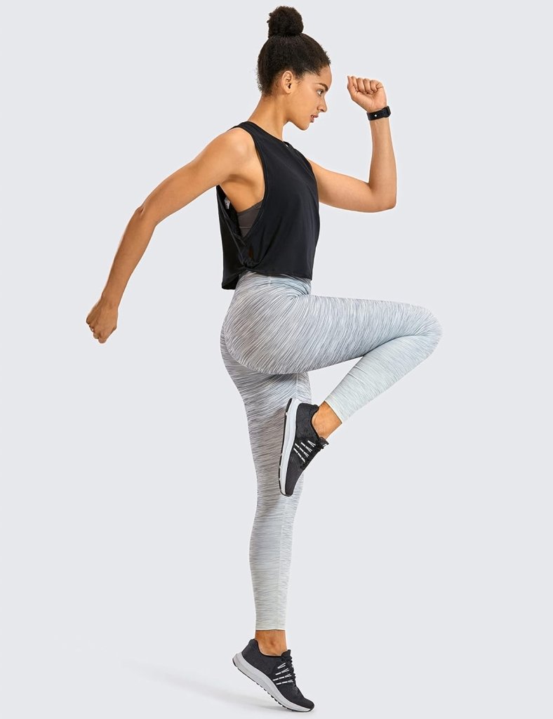 Laad afbeelding in Galerijviewer, Een persoon die de &quot;Stijlvol en comfortabel: Yoga dames pima cotton workout tank crop&quot; draagt, voert een oefening uit waarbij de knieën omhoog worden geheven tegen een effen achtergrond.
