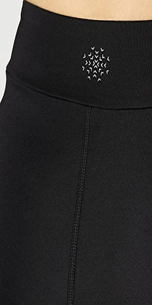 Close-up van de Ervaar comfort en stijl met onze sportlegging voor dames tailleband met ritssluiting en een decoratief patroon van witte geborduurde sterren.