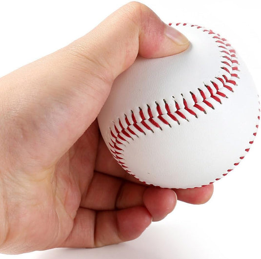 Een hand die een Perfecte PVC honkballen trainingsballen vasthoudt met rode stiksels tegen een witte achtergrond.