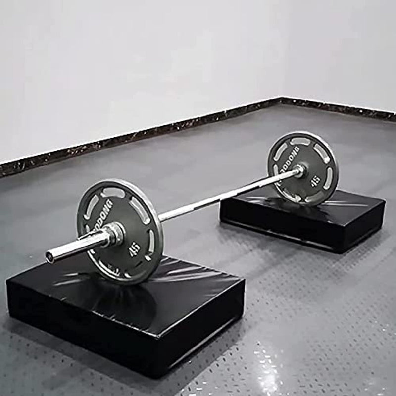 Laad afbeelding in Galerijviewer, Een halter met gewichten geplaatst op twee zwarte platforms met halterpads: de ultieme bescherming voor je halter en vloer, op een grijze tegelvloer in een sportschool.
