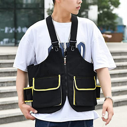 Een man met een zwart vest met gele waterdichte zakken en de Anti-diefstal borsttas voor fitness: de beste tas voor je training met een verstelbare schouderband.