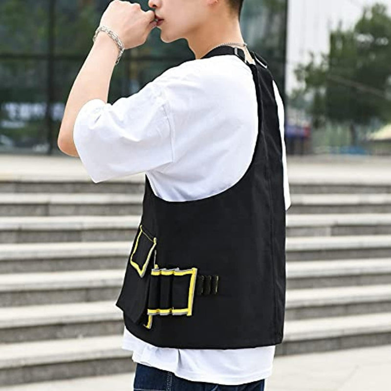 Laad afbeelding in Galerijviewer, Een jonge man, gekleed in een wit overhemd en een zwart vest met een Anti-diefstal borsttas voor fitness, staat buiten en kijkt weg van de camera.
