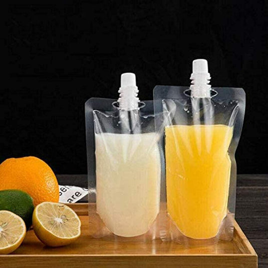 Staande drinkzakken: de veelzijdige en praktische oplossing voor al je drankbehoeften gevuld met sap, lekvrij en verzegeld, uitgestald op een houten oppervlak met citrusfruit ernaast.
