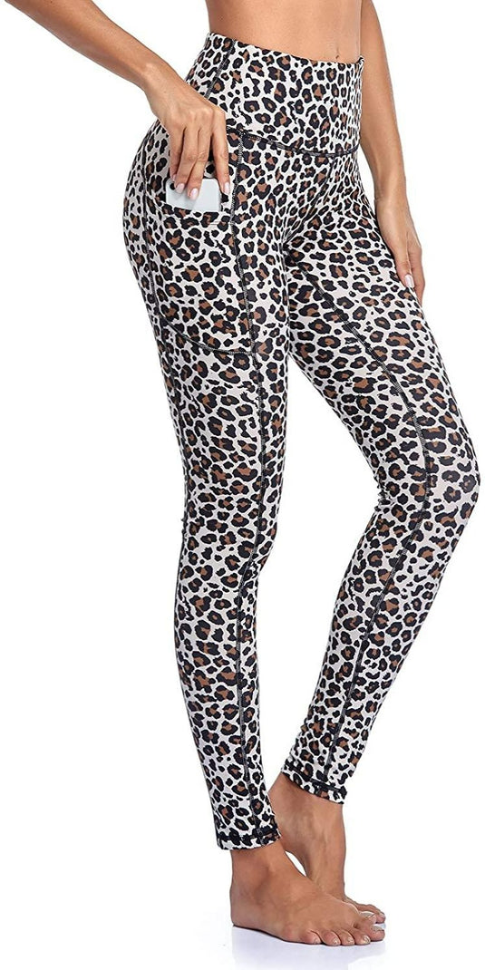Vrouw staat op haar tenen in een hoge taille legging dames met luipaardprint, handdeel in de zak aangestoken.