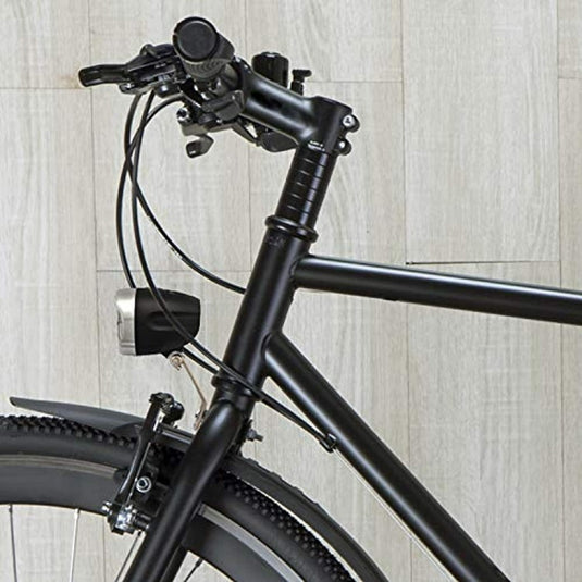 Een zwarte "Heldere fietslamp met StVZO goedkeuring: veilig en efficiënt" is bevestigd aan een fiets die tegen een houten wand geparkeerd staat.