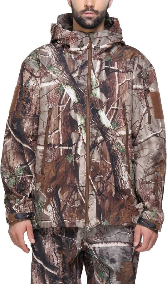 Man met een camouflage tactische heren softshell jas met capuchon, staande tegen een effen achtergrond.