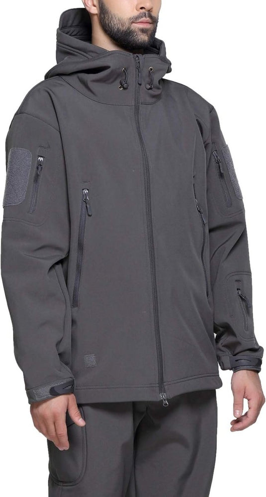 Man met een camouflage tactische heren softshell jas met meerdere zakken met ritssluiting, staand met een neutrale uitdrukking.